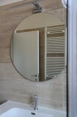 a mirror on a wall above a bathroom sink at Vatican Jacuzzi House in Rome