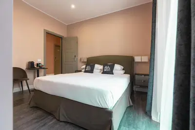 a bedroom with a bed with white sheets and pillows at My Rooms in Vatican City in Rome