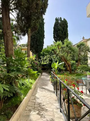 a walkway in a garden with trees and flowers at EppyTime Roma in Rome