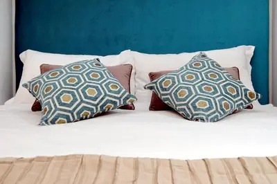 a bed with three pillows on top of it at EVE Guest House at Trevi Fountain in Rome
