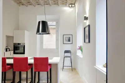 a kitchen with red chairs and a kitchen island at EVE Guest House at Trevi Fountain in Rome