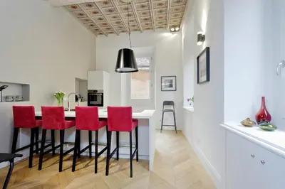 a kitchen with a bar with red stools at EVE Guest House at Trevi Fountain in Rome
