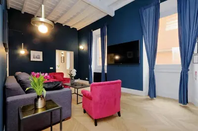 a living room with a couch and a pink chair at EVE Guest House at Trevi Fountain in Rome