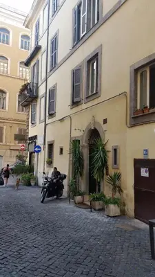 a man on a motorcycle parked in front of a building at Diapason Colosseo Suite in Rome