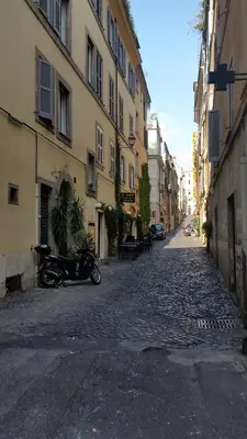a cobblestone street with a motorcycle parked on the side at Diapason Colosseo Suite in Rome