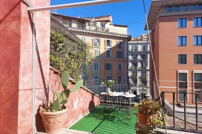 a balcony with a table and chairs and buildings at Leonina Terrace - My Extra Home in Rome