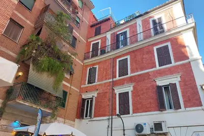 a red brick building with a balcony on it at Leonina Terrace - My Extra Home in Rome