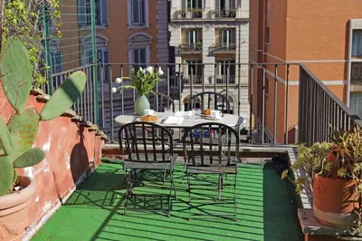 a patio with two chairs and a table on a balcony at Leonina Terrace - My Extra Home in Rome