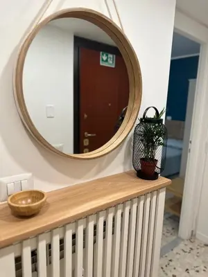 a mirror on a wall next to a table with a plant at Alloggio turistico Gloria in Rome