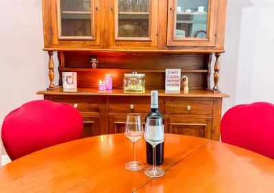 a bottle of wine and two glasses on a wooden table at Luminoso a due passi da Piazza Bologna in Rome