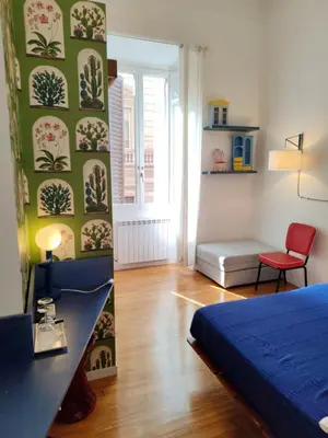 a bedroom with a blue bed and a green wall at Babbo Guest House in Rome