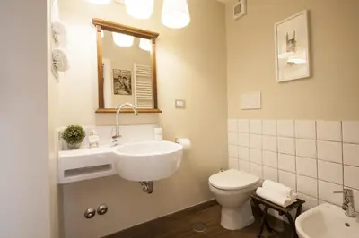 a white bathroom with a sink and a toilet at Babbo Guest House in Rome