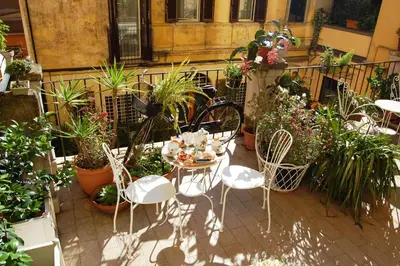 a patio with a table and chairs and potted plants at Babbo Guest House in Rome