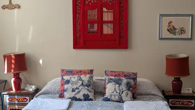 a bedroom with a bed with two pillows and a red picture at Babbo Guest House in Rome