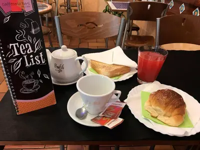 a table topped with a sandwich and a cup of coffee at Trastevere Dream House in Rome