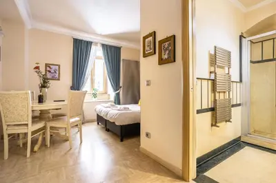 a bedroom with a bed and a table and a desk at Opera Theater Relais in Rome
