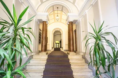 a hallway with stairs in a building with plants at Opera Theater Relais in Rome