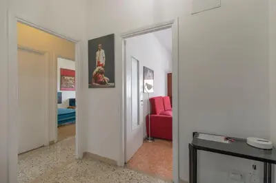 a hallway with a red chair and a mirror at Casa Lilly, appartamento luminosissimo a Roma in Rome