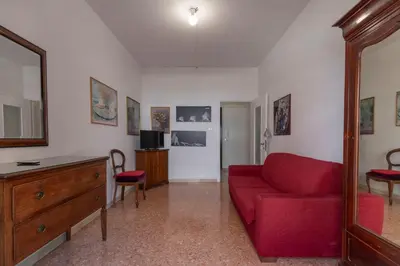 a living room with a red couch and a dresser at Casa Lilly, appartamento luminosissimo a Roma in Rome