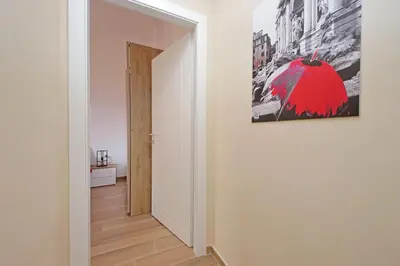 a hallway with a red umbrella painting on the wall at Prestigious Re di Roma Apartment in Rome