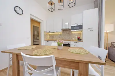a kitchen and dining room with a wooden table and chairs at Prestigious Re di Roma Apartment in Rome