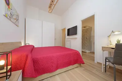 a bedroom with a red bed and a desk at Prestigious Re di Roma Apartment in Rome