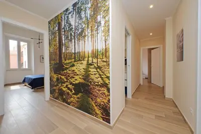 a hallway with a large wall painting of a forest at Prestigious Re di Roma Apartment in Rome