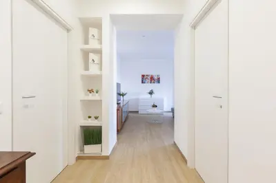 a hallway with white walls and wooden floors at Hostly-Libia Light Lodge-10min Metro to Colosseum in Rome