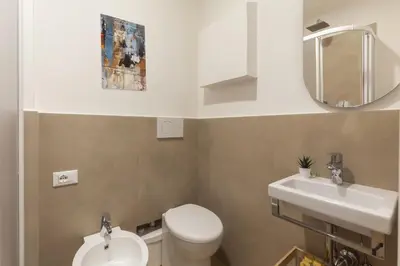 a bathroom with a toilet and a sink and a mirror at Hostly-Libia Light Lodge-10min Metro to Colosseum in Rome