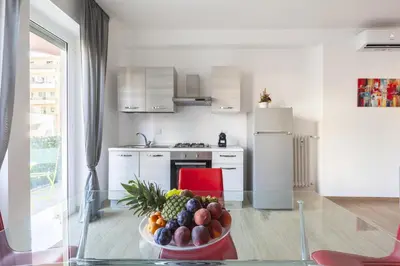 a kitchen with a bowl of fruit on a glass table at Hostly-Libia Light Lodge-10min Metro to Colosseum in Rome