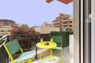 a yellow table with two chairs on a balcony at Hostly-Libia Light Lodge-10min Metro to Colosseum in Rome