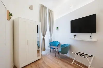 a living room with blue chairs and a tv at PAX apartment in Rome