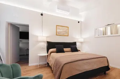 a bedroom with a large bed and a chair at PAX apartment in Rome