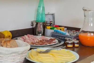 a table with two plates of food and orange juice at Flat 285 La Suite in Rome