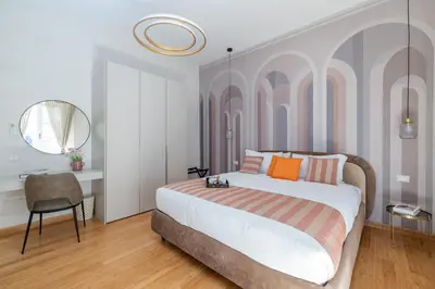 a bedroom with a bed and a table and a mirror at Angela luxury home,Premium Apartment for families in Rome