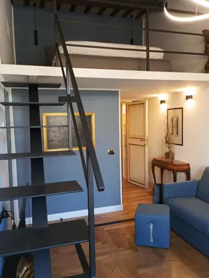 a living room with a loft bed and a blue couch at QUIRINALE 56 suite in Rome