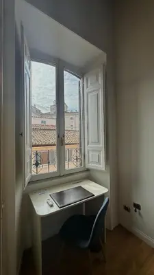 a room with a desk and a window with a view at QUIRINALE 56 suite in Rome