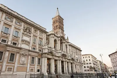 an old building with a clock tower in a city at White Flat Colosseo in Rome