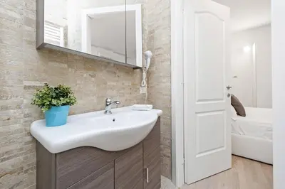a bathroom with a sink and a mirror at White Flat Colosseo in Rome