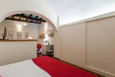 a bedroom with a bed and a red rug at Colosseum Townhouse in Rome