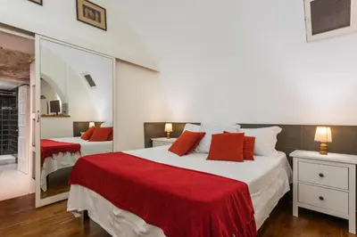 a bedroom with two beds and a mirror at Colosseum Townhouse in Rome