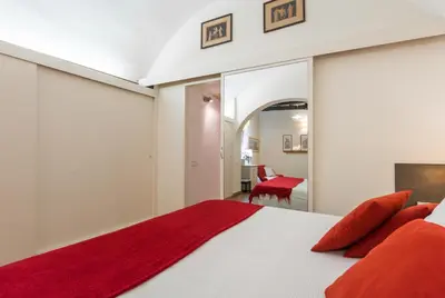 a bedroom with a large white bed with red pillows at Colosseum Townhouse in Rome