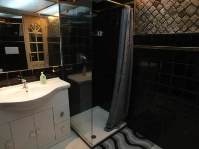 a bathroom with a sink and a shower with a shower curtain at Colosseum Townhouse in Rome