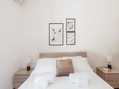 a bedroom with a white bed with three pictures on the wall at The Best Rent - Spacious flat a stone's throw from the Vatican in Rome