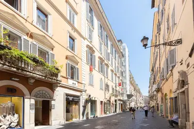 a city street with buildings and people walking down the street at Amazing Piazza di Spagna in Rome