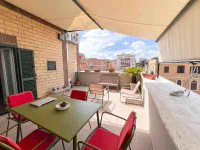 a patio with a table and chairs on a balcony at Attico Urbano Terrazza su Roma Metro A Cornelia in Rome