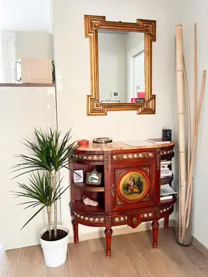 a wooden dresser with a mirror and a potted plant at Attico Urbano Terrazza su Roma Metro A Cornelia in Rome