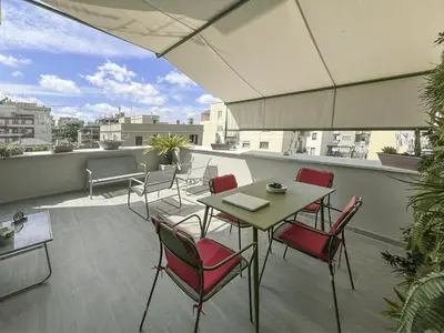 a patio with a table and chairs on a roof at Attico Urbano Terrazza su Roma Metro A Cornelia in Rome