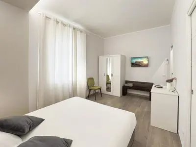 a bedroom with a white bed and a desk at Attico Urbano Terrazza su Roma Metro A Cornelia in Rome