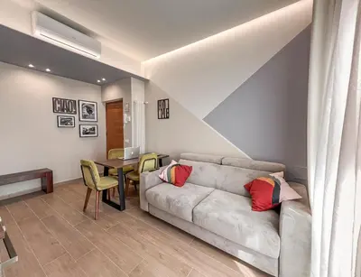 a living room with a couch and a table at Attico Urbano Terrazza su Roma Metro A Cornelia in Rome